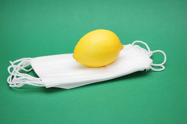 Egy sárga citrom található egy halom orvosi maszk. Vírusok és fertőzések elleni védelem. — Stock Fotó