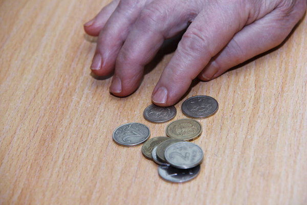 The pensioner's hand count coins. Russian rouble. Below the breadline. Pension reform concept.