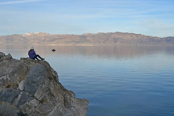 Wanita muda menikmati pemandangan tenang Piramida Danau, Nevada dari formasi batu di pantai . — Stok Foto