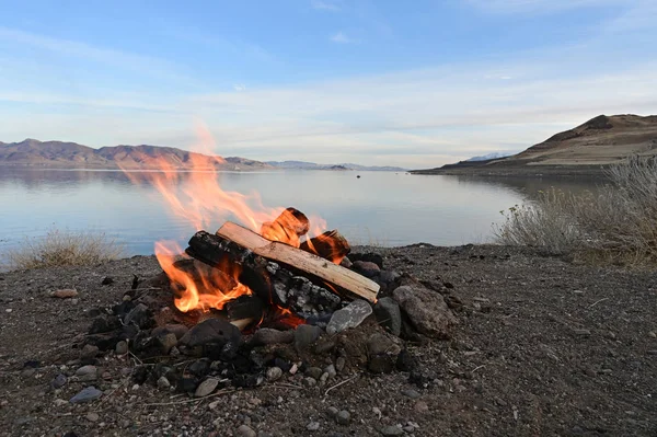 Api unggun pada formasi batuan yang menghadap ke Danau Piramida, Nevada dengan danau di latar belakang . — Stok Foto