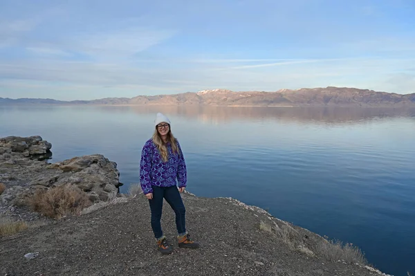 Jeune femme bénéficie d'une vue sur le lac Pyramid tranquille, Nevada de la formation de rochers sur la côte . — Photo