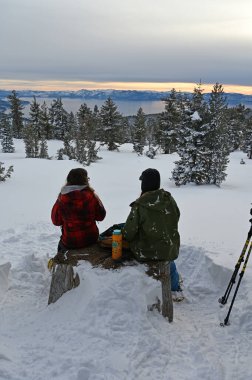 Two young women snowshoeing above Lake Tahoe, Nevada. clipart