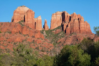 Cathedral Rock above green summer foliage near Sedona, Arizona.