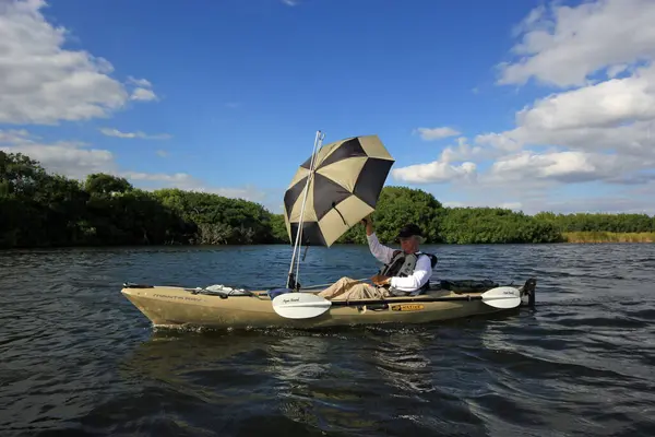 エバーグレーズ国立公園のポーロティス池で傘を帆として使う活動的なシニアカヤック. — ストック写真