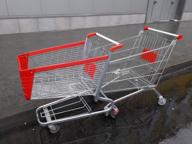 Market ürünleri için el arabaları bir süpermarketin yanında duruyor.