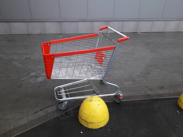 Carts for grocery products stand near a supermarket on the stree