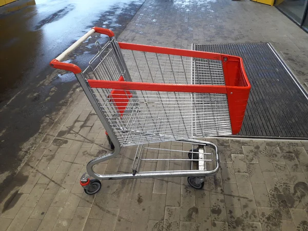 Carts for grocery products stand near a supermarket on the stree