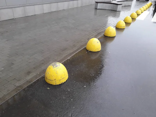 Limitadores amarelos na estrada para um carro de concreto — Fotografia de Stock