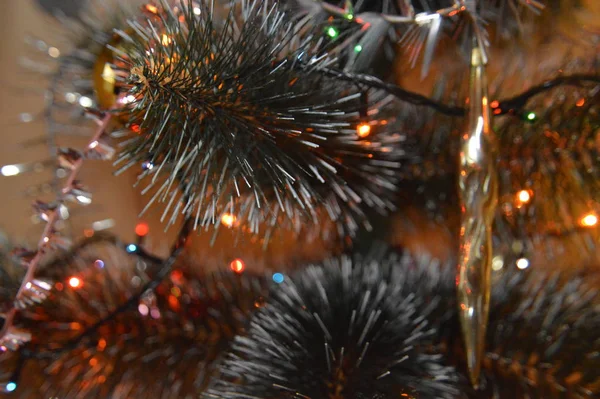 Kerstboom met speelgoed en lichtgevende bloemenslingers thuis en in de — Stockfoto