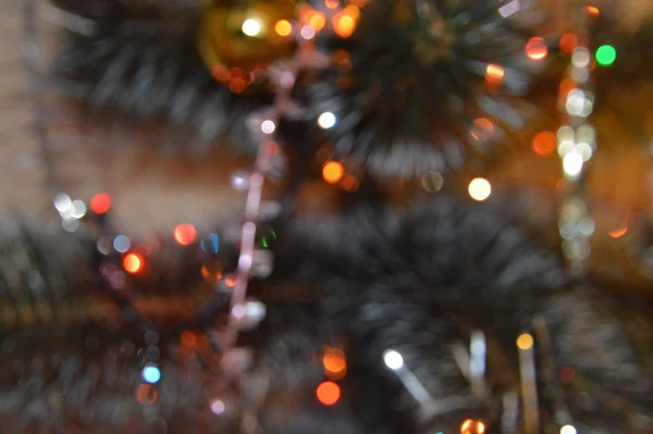 Kerstboom met speelgoed en lichtgevende bloemenslingers thuis en in de — Stockfoto