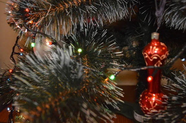 Kerstboom met speelgoed en lichtgevende bloemenslingers thuis en in de — Stockfoto