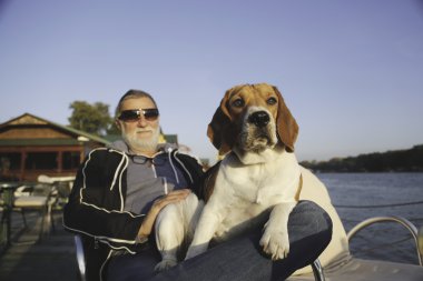 Köpeğiyle bir nehir kıyısında oturan olgun adam