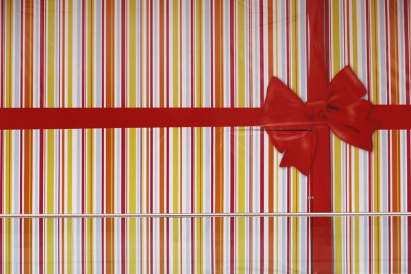 Red ribbons with bow for gift wrapping on multicoloured backgrou — ストック写真