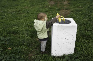 Genç çocuk parkı çöp kutusu içine muz kabuğu atma