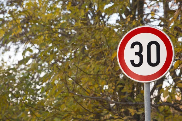 Обмеження швидкості тридцять знаків поруч зі шкільним парком — стокове фото