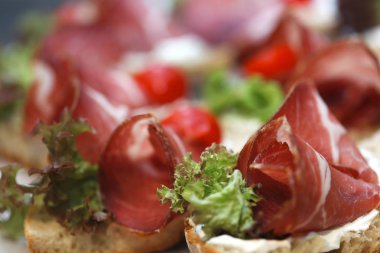 Mozzarella peyniri, jambon ve domates ile küçük sandviç.