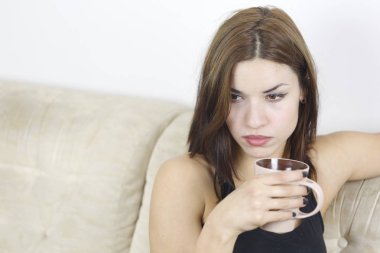 Genç çekici esmer koltukta kahve içme 