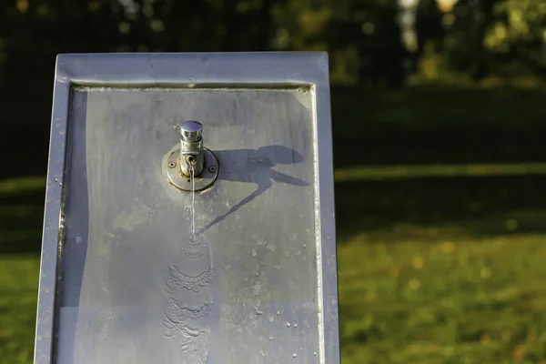 Modern metal drinking fountain dropping water — Stock Photo, Image