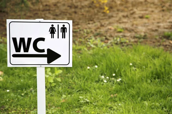 Toilet sing for man and female on white table in nature — Stock Photo, Image