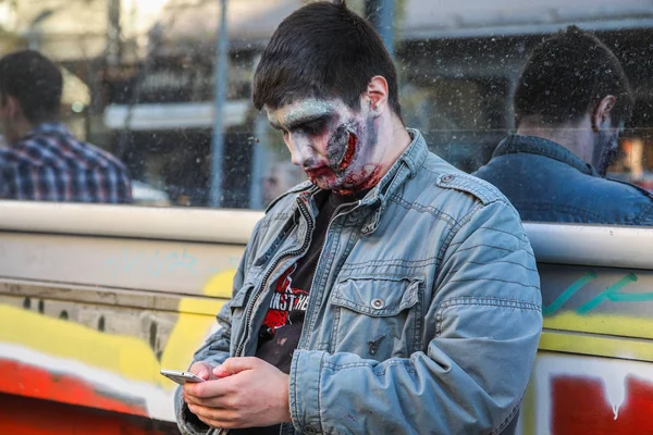 Mężczyzna makijaż jak zombie wykorzystuje telefon komórkowy — Zdjęcie stockowe