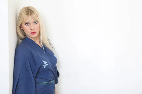 Blond håret kvinde klædt i blå kimono - Stock-foto