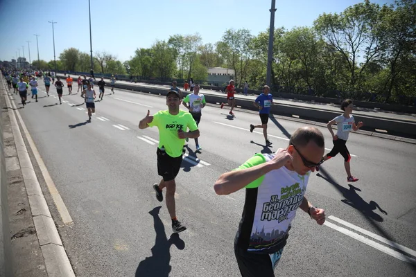 Competidores da trigésima primeira corrida internacional da Maratona de Belgrado atravessam a Ponte Brankov sobre o rio Sava — Fotografia de Stock