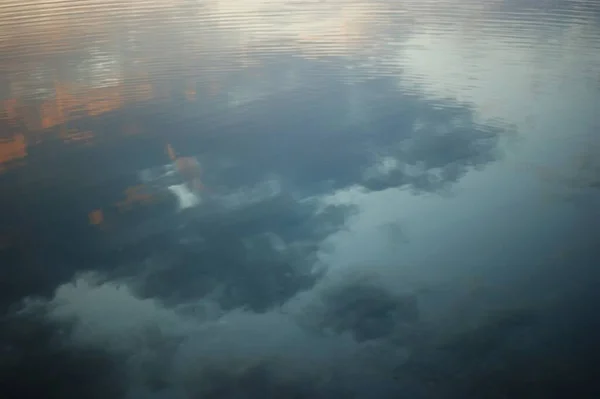 Schöner Sonnenuntergang über dem See mit Spiegelung im Wasser, majestätische Wolken am Himmel — Stockfoto