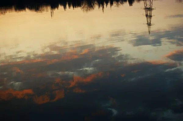 Hermosa puesta de sol sobre el lago con reflejo en el agua, majestuosas nubes en el cielo —  Fotos de Stock