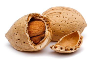 Çatlak ve bütün badem beyaz arka planda izole edilmiş. Macro, stüdyo çekimi.