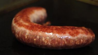 Şef sosis pişirme plaka üzerinde döner..