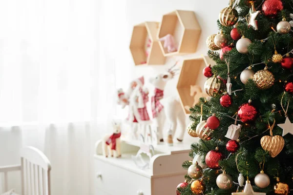 Scaffale con figure natalizie Babbo Natale e Cervi nella cameretta dei bambini. Interno di Natale di camera da letto da bambini. L'arredamento di anno nuovo e l'albero in sala giochi da bambini. ? hristmas nella stanza dei bambini . — Foto Stock