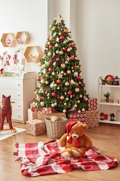 Interior de Natal do quarto das crianças. A decoração de Ano Novo e árvore na sala de jogos de crianças. Interior estilo loft de Natal. Hristmas no berçário. urso de brinquedo macio no fundo da árvore de Natal — Fotografia de Stock