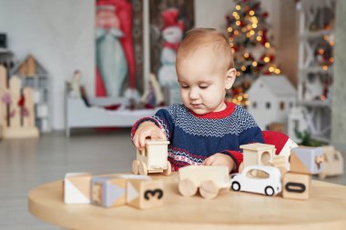 Sevimli küçük çocuk oyuncak ahşap tren, oyuncak araba, piramit ve küplerle oynuyor, öğrenim geliştirme konsepti. Çocukların gelişimi iyi motor beceriler, hayal gücü ve mantıklı düşünme