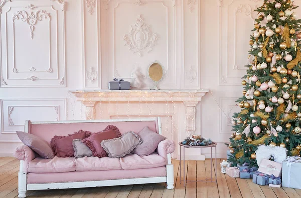 Interior de sala de estar de luxo com sofá decorado árvore de Natal chique, presentes e travesseiros. Interior clássico em tons rosa. Natal em casa. Sofá rosa no fundo da árvore de Natal. Modelo de cartão postal — Fotografia de Stock