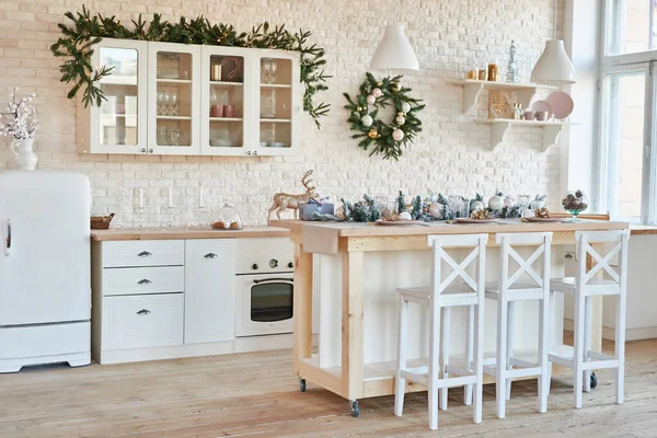 Cocina interior luminosa con decoración navideña y árbol. Cocina blanca en estilo clásico. Navidad en la cocina. Cocina luminosa en tonos blancos con Navidad . — Foto de Stock