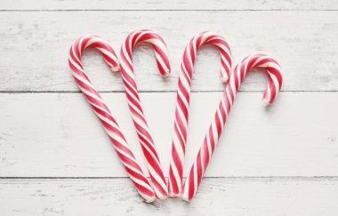 Beyaz ahşap arka planda Noel şekeri bastonu yakın plan. Düz yerde, üst tarafta. Yılbaşı kartı şablonu ve mesaj için boşluk. Tatil sezonu, Noel havası.