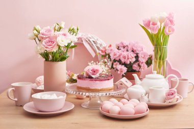 Paskalya sofrası pasta, yumurta ve çiçeklerle dolu. Mutlu Paskalya tebrik kartı şablonları. Paskalya pastası ve renkli yumurtalar festival masasında. Aile kutlaması konsepti. Paskalya tatili