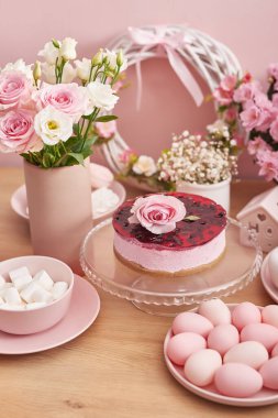 Paskalya sofrası pasta, yumurta ve çiçeklerle dolu. Mutlu Paskalya tebrik kartı şablonları. Paskalya pastası ve renkli yumurtalar festival masasında. Aile kutlaması konsepti. Paskalya tatili