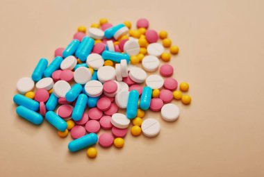 Bej arka planda çeşitli ilaç hapları, haplar ve kapsüller. Bir sürü hap. Koronovirüs, karantina, salgın, salgın, grip, soğuk algınlığı, hastalık. Tıp konsepti ve sağlık.