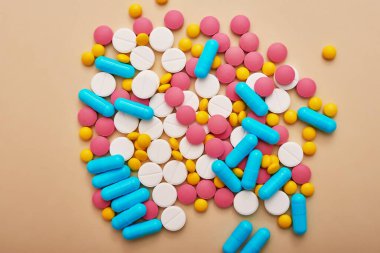 Bej arka planda çeşitli ilaç hapları, haplar ve kapsüller. Bir sürü hap. Koronovirüs, karantina, salgın, salgın, grip, soğuk algınlığı, hastalık. Tıp konsepti ve sağlık.
