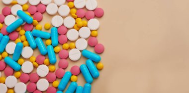 Bej arka planda çeşitli ilaç hapları, haplar ve kapsüller. Bir sürü hap. Koronovirüs, karantina, salgın, salgın, grip, soğuk algınlığı, hastalık. Tıp konsepti ve sağlık.