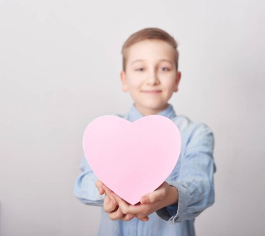 Hediye kutusu olan çocuk. Anneler Günü tebrik kartı. Mutlu anneler günü geçmişi. Bahar kartı şablonu. Mutlu yıllar ya da Sevgililer Günü. Kadınlar Günü. Uzayı kopyala Pembe kalp şeklinde hediye kutusu..