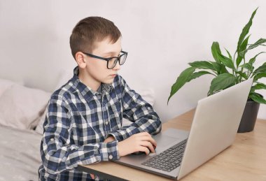 Evde online ders, karantina sırasındaki sosyal mesafe, kendini izole etme, online eğitim konsepti, evde eğitim. Çocuk internette dil öğreniyor, dizüstü bilgisayar kullanıyor, uzaktan eğitim alıyor. Öğrenci çocuk, okul..