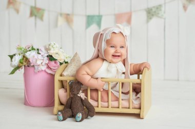 Tavşan kulaklı şirin bir bebek. Paskalya tebrik kartı, metnin için kopyalama alanı. Paskalya tatili için poster. Paskalya tavşanı. Anneler Günü için tebrikler. Paskalya tavşanı. Sevimli kız 6 aydır yatakta.