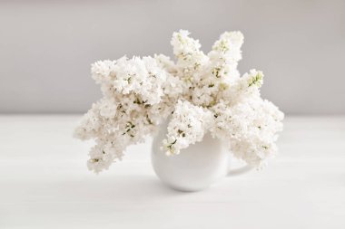 Mutfaktaki masada vazoda bir demet beyaz leylak. Doğum günün kutlu olsun. Merhaba bahar ve yaz. Kadınlar Günü ve Anneler Günü için tebrik kartı. Bahar mevsimi, kopyalama alanı.