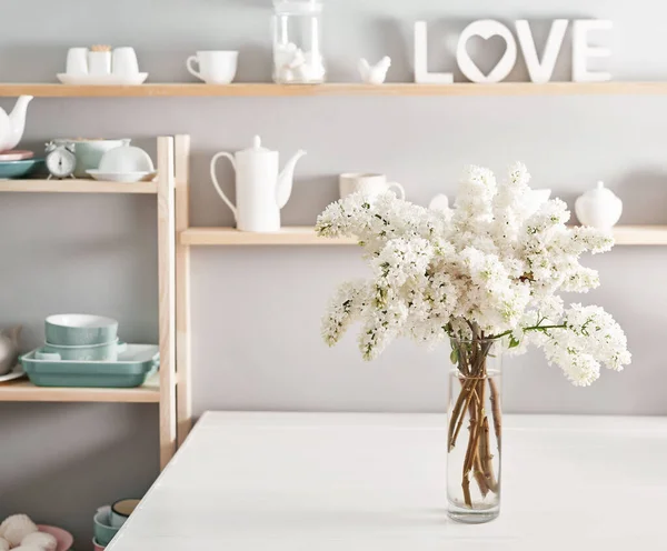 Bouquet of white lilac in vase on table in kitchen. Happy birthday greeting card. Hello spring and summer. Greeting card for Women's Day and Mother's Day. Spring season, copy space.