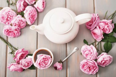 Gri ahşap masada pembe güllü çay, kopya spase. Anneler günü için tebrik kartı. Sevgililer günü kartı. 14 Şubat Sevgililer Günü Romantik Kahvaltısı. Kadınlar Günü. Mutlu yıllar! Düğün davetiyesi.