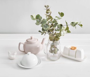 Akşam yemeği için minimalist masa ayarları. Çay kompozisyonu. Beyaz mutfak masasında ev eşyası, ön manzara, kopyalama alanı