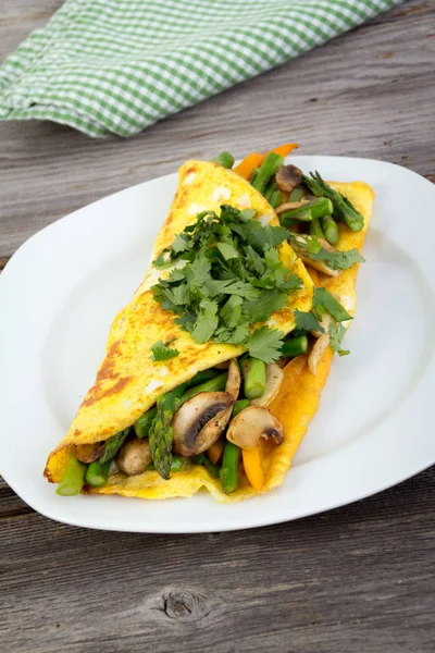 Ahşap arka plan üzerinde doldurulmuş sebze omlet