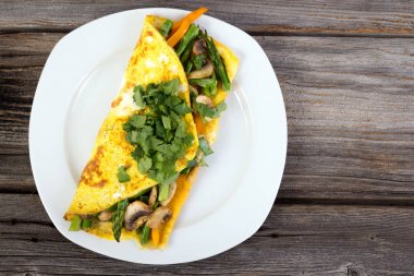 Ahşap arka plan üzerinde doldurulmuş sebze omlet